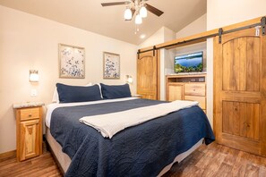 A bedroom with a bed, wooden wardrobe, and a television on a stand. - Peaceful Lakefront Tiny Cabin Nestled in the Sabine National Forest for a Romantic Escape in Hemphill, Texas (Hemphill)