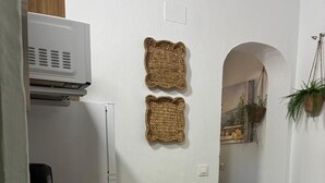 A room with a wooden table, a microwave, and two woven baskets on the wall. - Exclusive three-bedroom home just a few minutes from the beach. (El Puerto de Santa María)