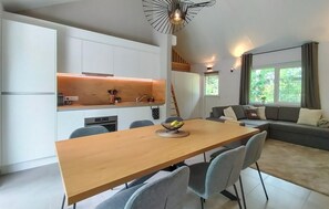 Eine moderne Küche mit weißen Schränken, einem Holzespeisetisch und einem eingebauten Herd.