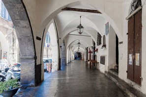 A corridor with arches, a hanging light fixture, and a wooden door. - CA' IN TE L'AIA - Taggia Centro (Taggia)