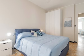 A bedroom with a bed, bedside table, and a wardrobe. - DA DADA - Parcheggio (Arma di Taggia)
