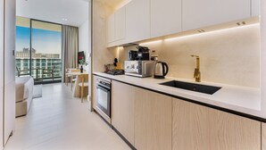 Una cocina moderna con horno empotrado, cafetera y hervidor.