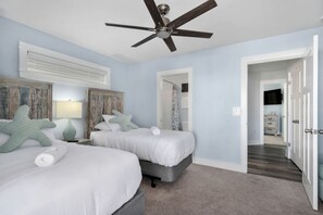 A bedroom with two beds, a ceiling fan, and a view into the hallway. - Luxury Coastal Escape with Private Pool, BBQ Grill & Family Amenities in Corolla, North Carolina (Corolla)