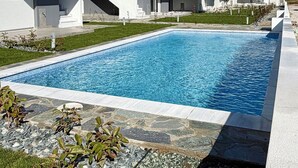 A modern residential building with a swimming pool, flat roof design, and a clear blue sky. - GREEN ALMOND D1.2 FAMILY FRIENDLY (Paralia Ofriniou)