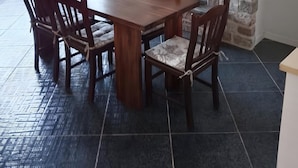 Ein Essbereich mit Holztisch und -stühlen, einem Kamin aus Stein und einer Klimaanlage.