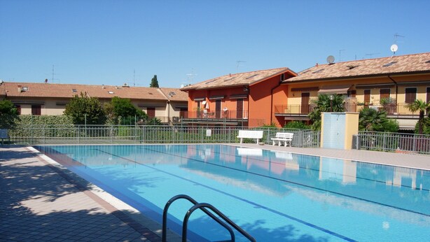 A swimming pool with a tiled deck, metal railings, and a bench. - Da Elena Apartment, two-room apartment with private garden, complex with pool and tennis court (Pacengo)