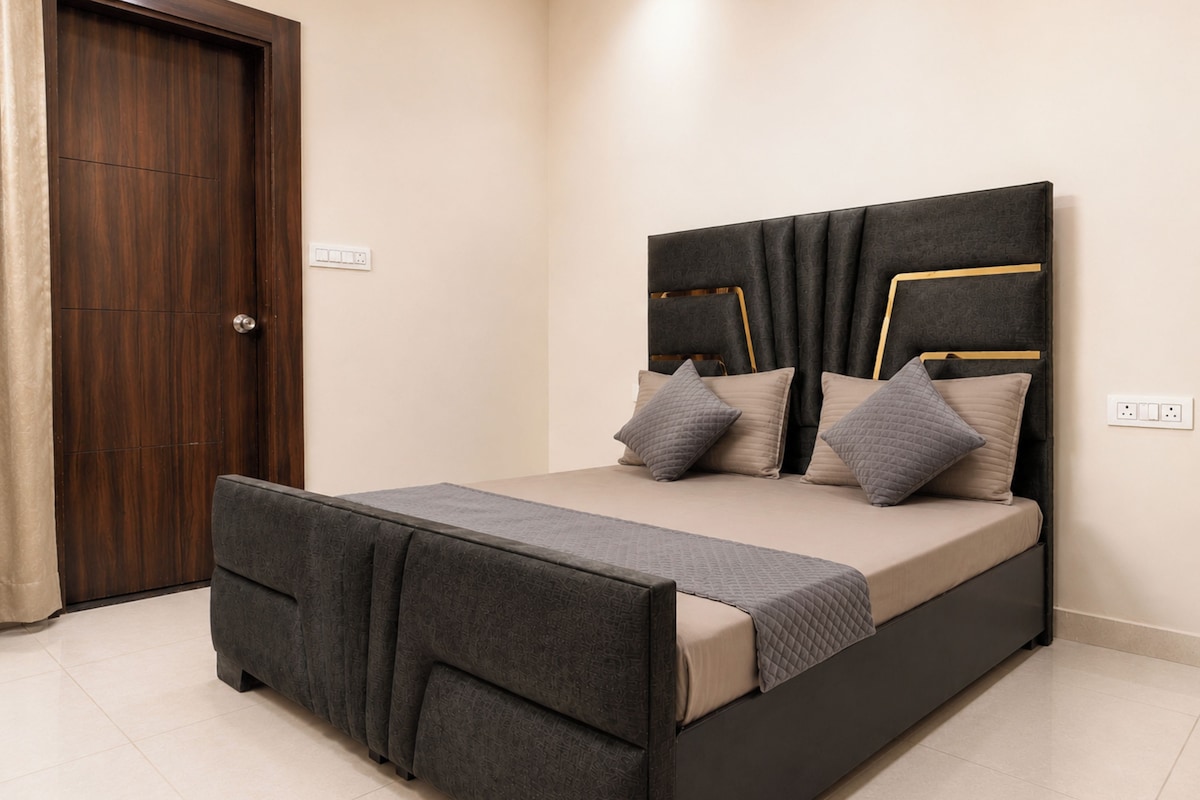 A bedroom with a bed, a wardrobe, and a door.
