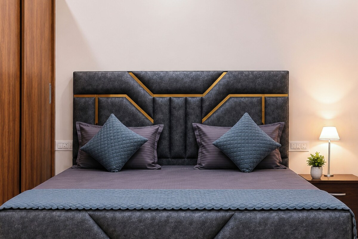 A bed with a headboard featuring a geometric pattern and two pillows.