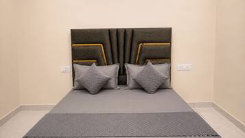 A bed with a headboard, two pillows, and a blanket.