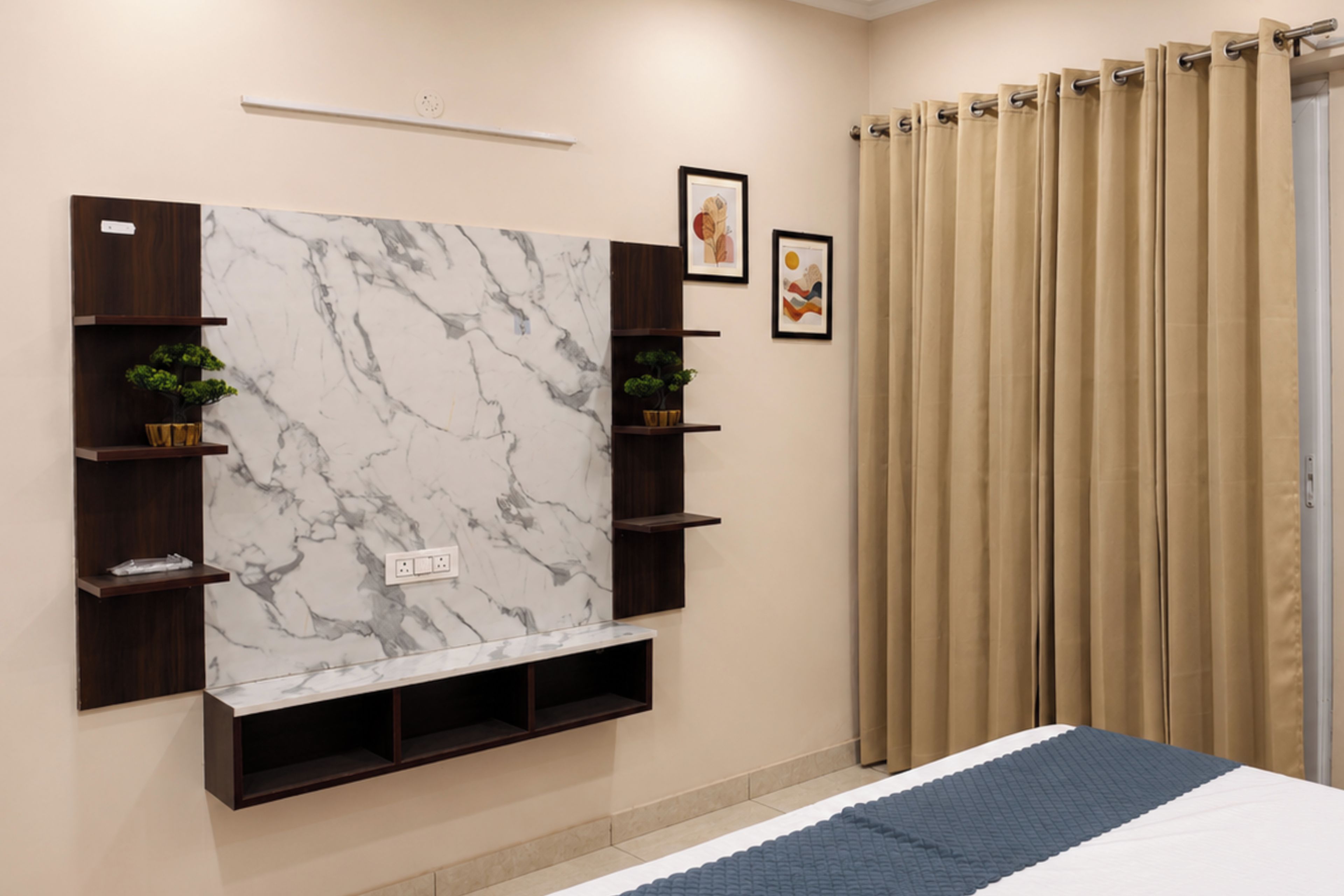 A bedroom with a bed, a marble wall unit, and a window with curtains.