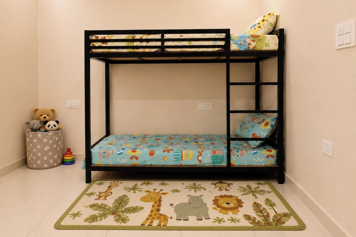 A bunk bed with a blue mattress featuring animal prints, a small bedside table, and a toy storage bin.
