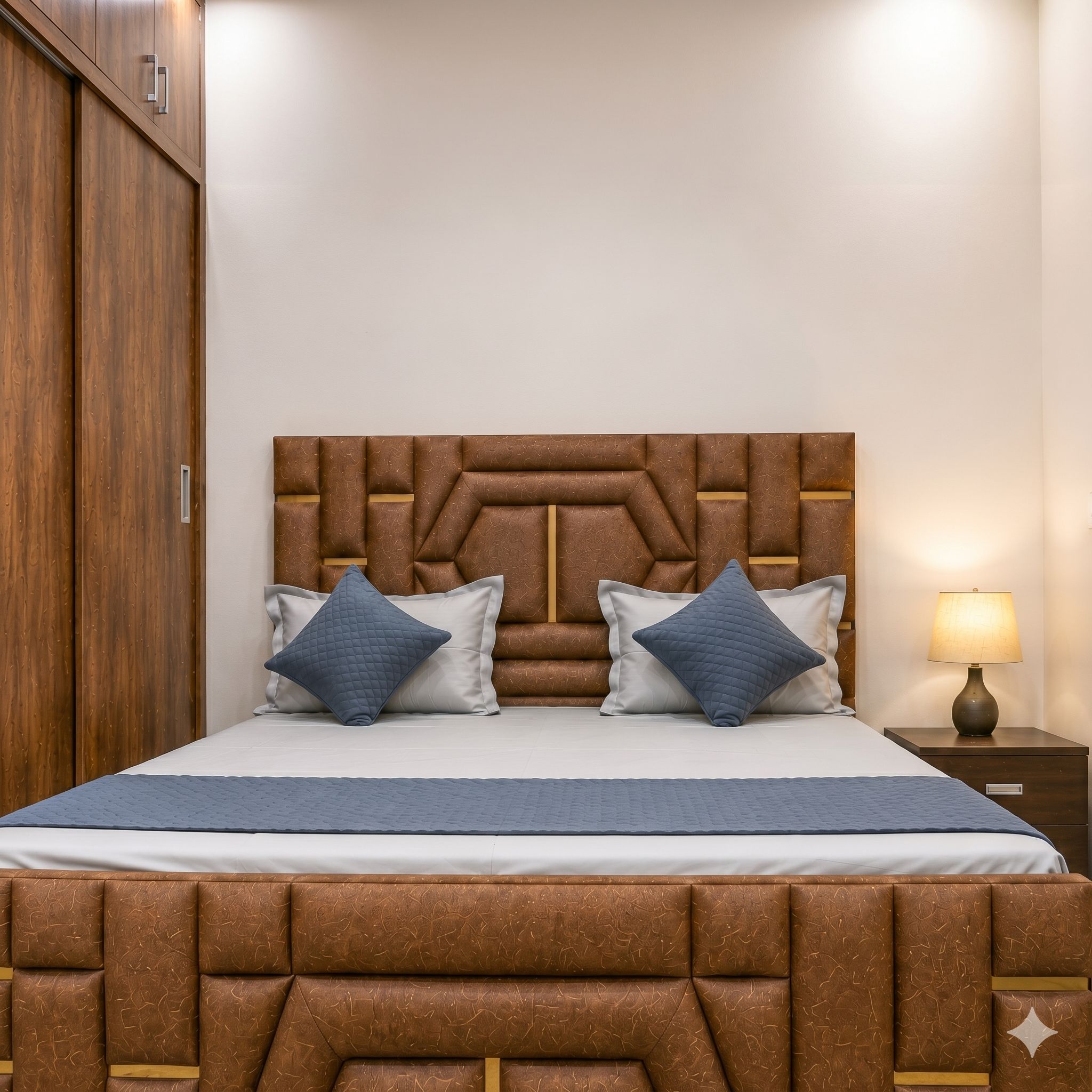 A bed with a headboard, two pillows, a bedside table with a lamp, and a wooden wardrobe.