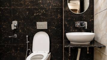 A modern bathroom with a toilet, bidet, and sink.