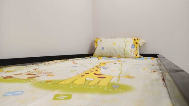 A bed with a giraffe-themed bedspread and a pillow with a giraffe pattern. - Aarambh Hillside View (Dehradun)