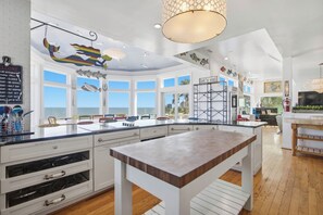 Een ruime keuken met grote ramen, een centraal eiland en uitzicht op de omgeving.