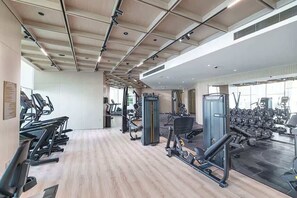 A gym with treadmills, weight machines, and a mirror wall. - Stylish New 1 bedroom with Private Jacuzzi -Binghatti (Dubai)