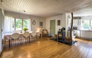 Ein gemütliches Zimmer mit Esstisch, Stühlen, Kamin und Küchenzeile.