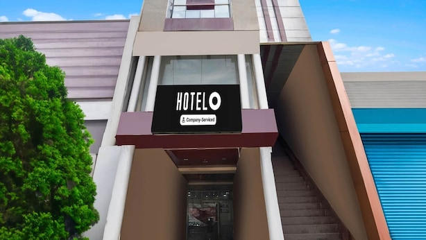 A hotel with a modern facade, a sign indicating it is company-serviced, and a staircase leading to the entrance. - Classic Hotel Shantila Inn (Prayagraj)