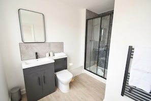 Ein modernes Badezimmer mit Dusche, Toilette und Waschtisch.