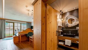 Una habitación de madera con un escritorio, una silla y un ventanal grande.