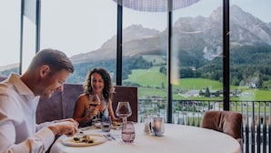 Una pareja cenando en una mesa con vistas a la montaña.