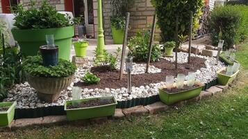 Un jardin agrémenté de différentes plantes en pot et d’un chemin pavé de pierres.