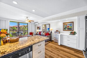 A modern kitchen with granite countertops, a dishwasher, and a dining area with a table and chairs. - Papakea Resort 2 Beachfront Villas, Sleeps 8 | Car Incl. w/ 6 nights | ML-4115 by KBM (Lahaina)