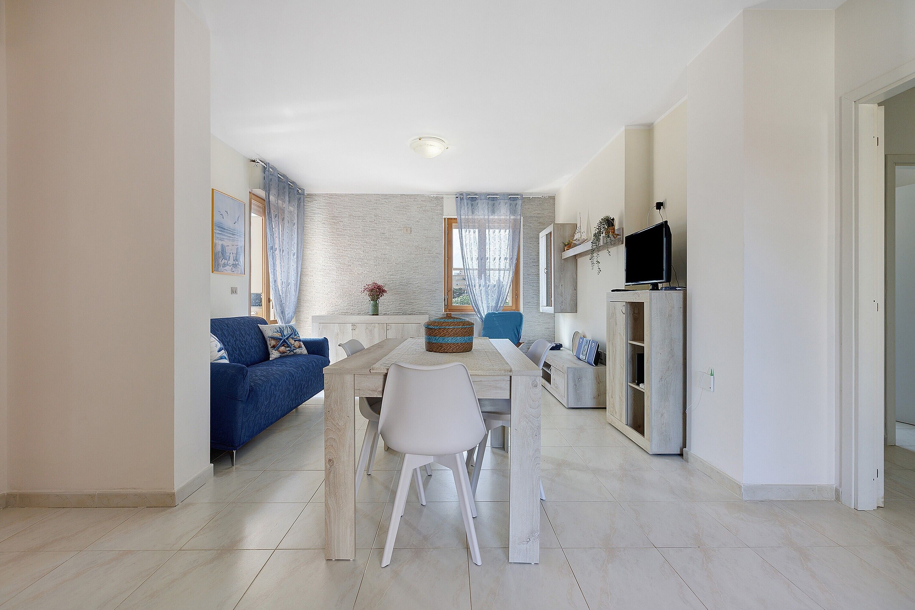 Un salon moderne avec une table à manger, un canapé et un téléviseur.
