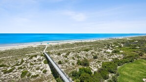Un paysage côtier avec un pont, une plage et une végétation clairsemée.