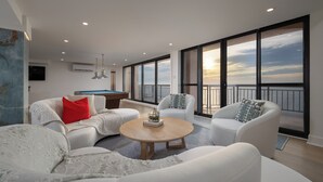A modern living room with a pool table, large windows, and a view of the sky. - Newly renovated luxury retreat with incredible views, features 6 bedrooms and 5 baths! (Ocean City)