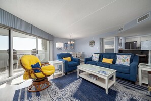 Ein modernes Wohnzimmer mit einem blauen Sofa, einem gelben Sessel und einem Glastisch.