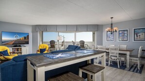 Una sala de estar moderna con una isla central, comedor y asientos.