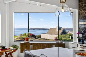 A modern kitchen with a large window overlooking a scenic view of the sea and hills. - Artist Haven This custom contemporary home showcases the best of Bodega Bay! (Bodega Bay)