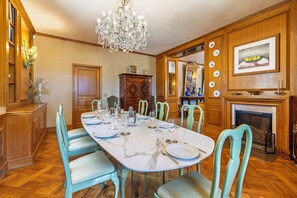 A dining room with a marble table, teal chairs, a chandelier, and a fireplace. - Villa Goffrey, Sicily (San Ciro - Ulmi - Filci)