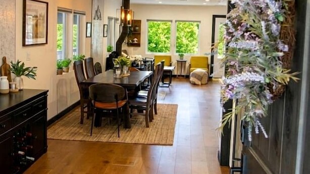 A spacious dining area with a long table, chairs, and a hanging light fixture. - Rustic Retreat with Private Pond, Gazebo & Creek in Andes, New York (Andes)