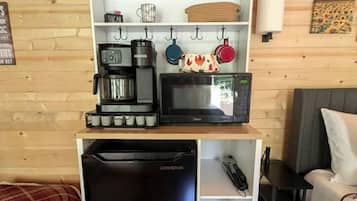 A compact kitchenette with a coffee maker, microwave, and a small refrigerator.