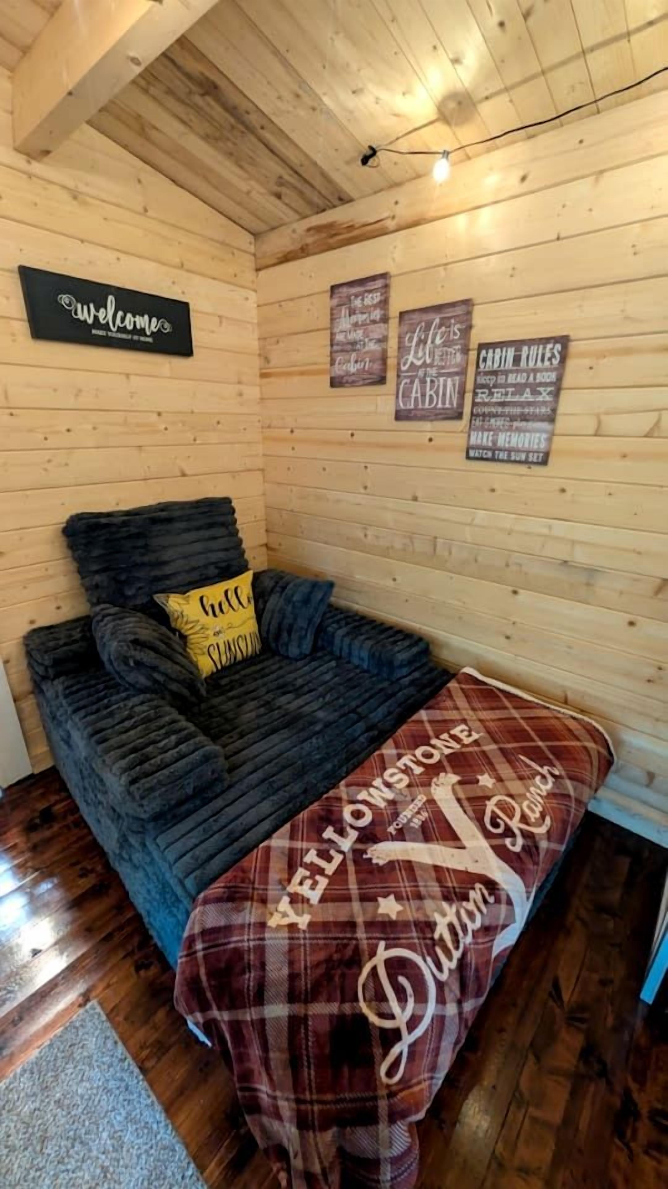 L’intérieur d’une cabine, avec un lit, une pancarte d’accueil et les règles de la cabine affichées sur les murs.