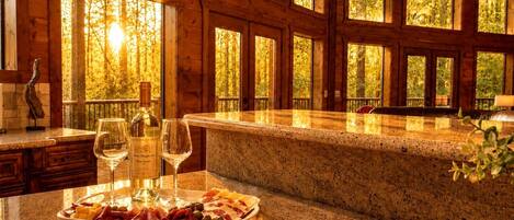 Un intérieur en bois avec un comptoir en marbre, une bouteille de vin et une planche de charcuterie.