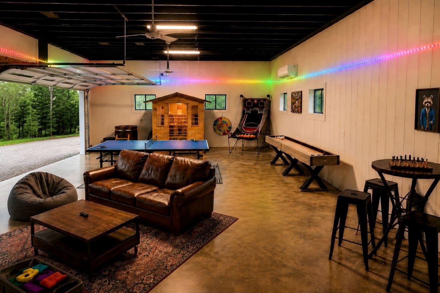 A cozy indoor space with a leather sofa, a ping pong table, a foosball table, and a ping pong table.