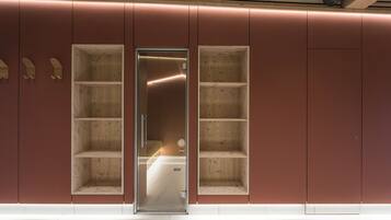 A modern interior with a glass door leading to a room with wooden shelving.