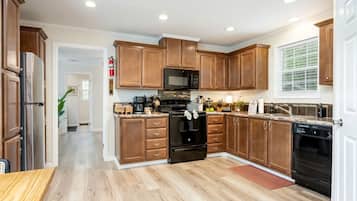 Una cocina moderna con armarios de madera, electrodomésticos de acero inoxidable y una encimera de granito.