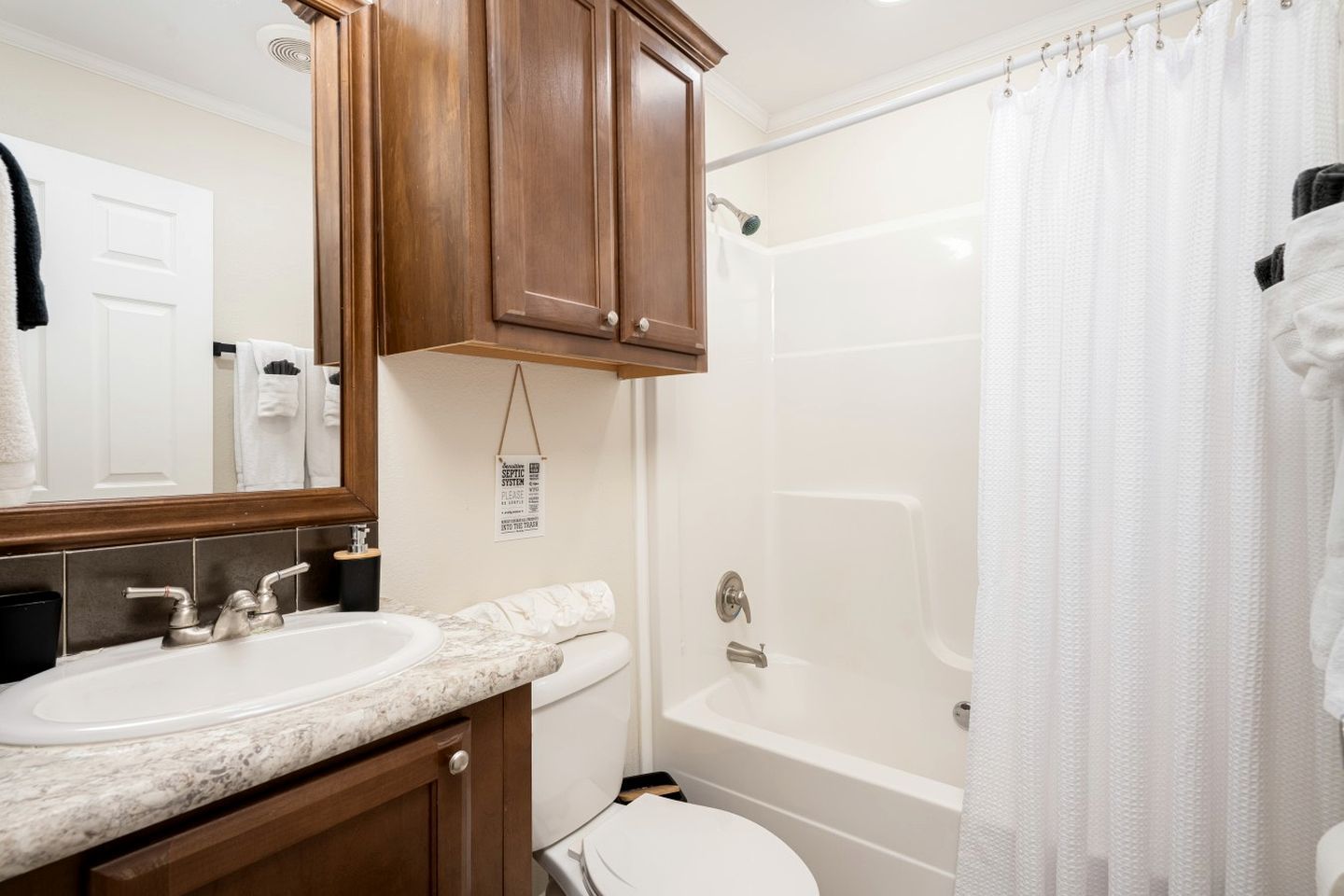 A bathroom with a double sink, a toilet, a bathtub, and a shower curtain.