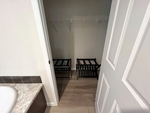 A narrow hallway with a bathroom on the left, a door on the right, and two wooden benches in the center. - Spacious Modern Cabin on Toledo Bend Lake with Gorgeous Deck and Patio for an Amazing Family Getaway in Hemphill, Texas (Hemphill)
