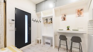 A modern room with a bed, a desk with two chairs, a small table, a black door, and a white wall with a power outlet. - (MDV120) Study in Carabanchel, Madrid (Madrid)