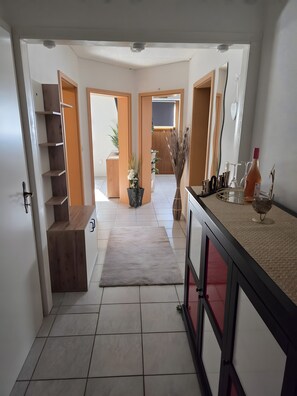 Una cocina moderna con alfombra gris, armarios de madera y una encimera con utensilios de cocina.