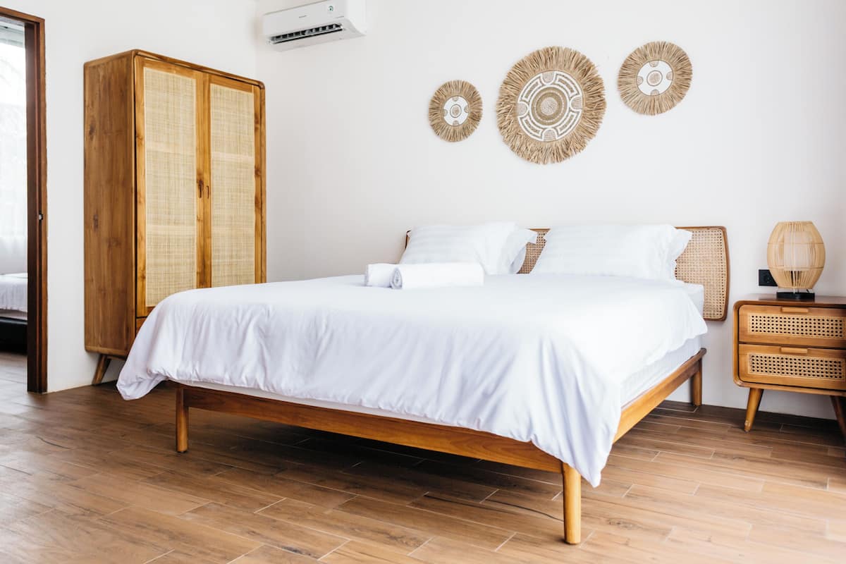 Un dormitorio con una cama de madera, un armario y tres adornos en la pared.