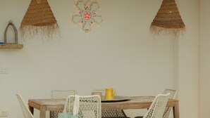 Un comedor con mesa de billar, cuatro sillas y dos lámparas colgantes.