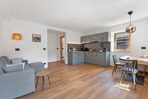 A modern apartment with a living room, kitchen, and dining area.