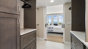 A modern bathroom with a large mirror, dark cabinets, and a shower area. - 1368 Shipwatch - Hosted by Moore AI Rentals (Fernandina Beach)