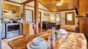 Un'ampia cucina con mobili in legno, un grande tavolo da pranzo e una ventola a soffitto.